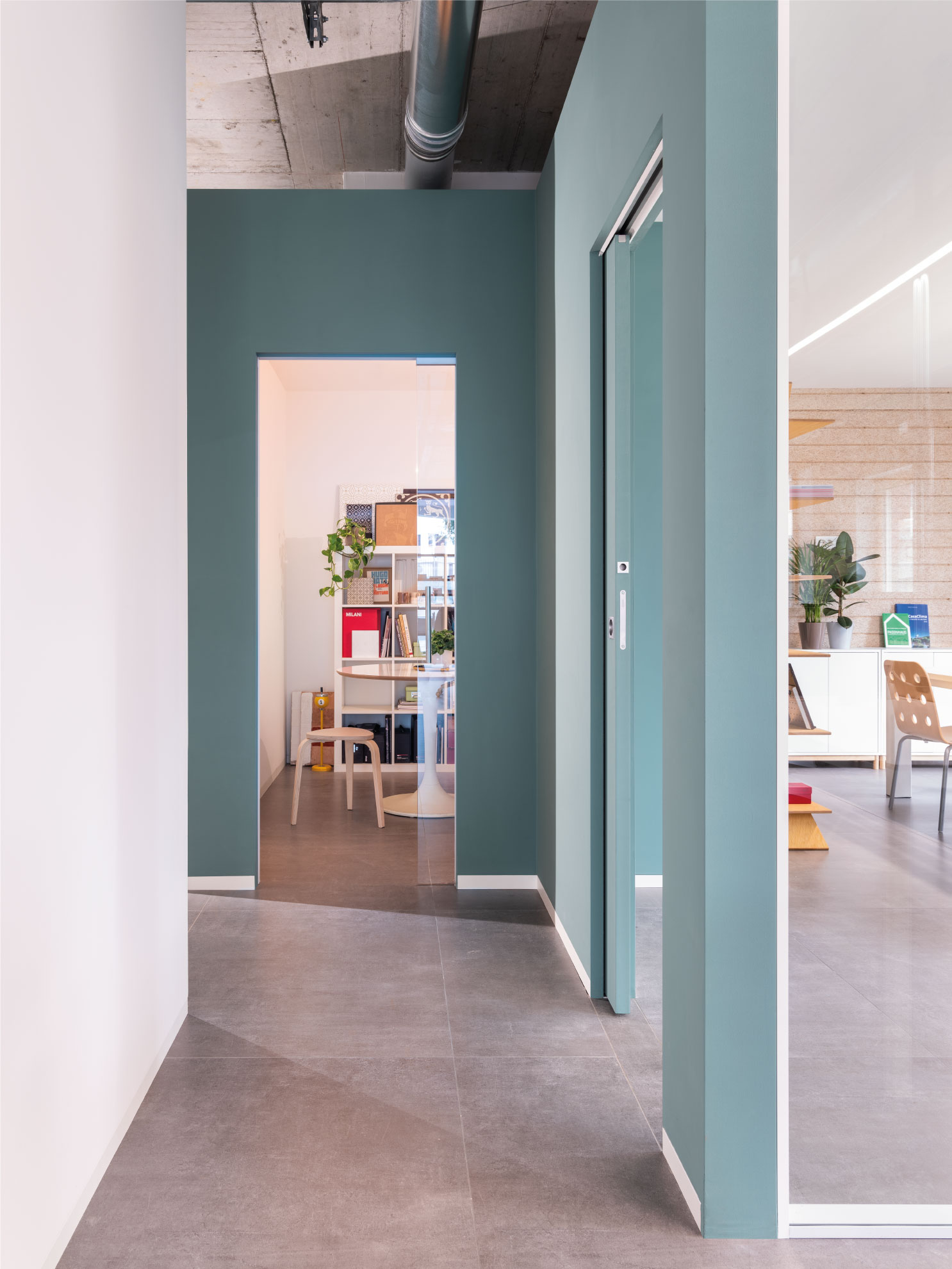 Couloir de l'open space donnant sur des bureaux et salle de réunion séparés par des porte coulissante Eclisse Syntesis® Line