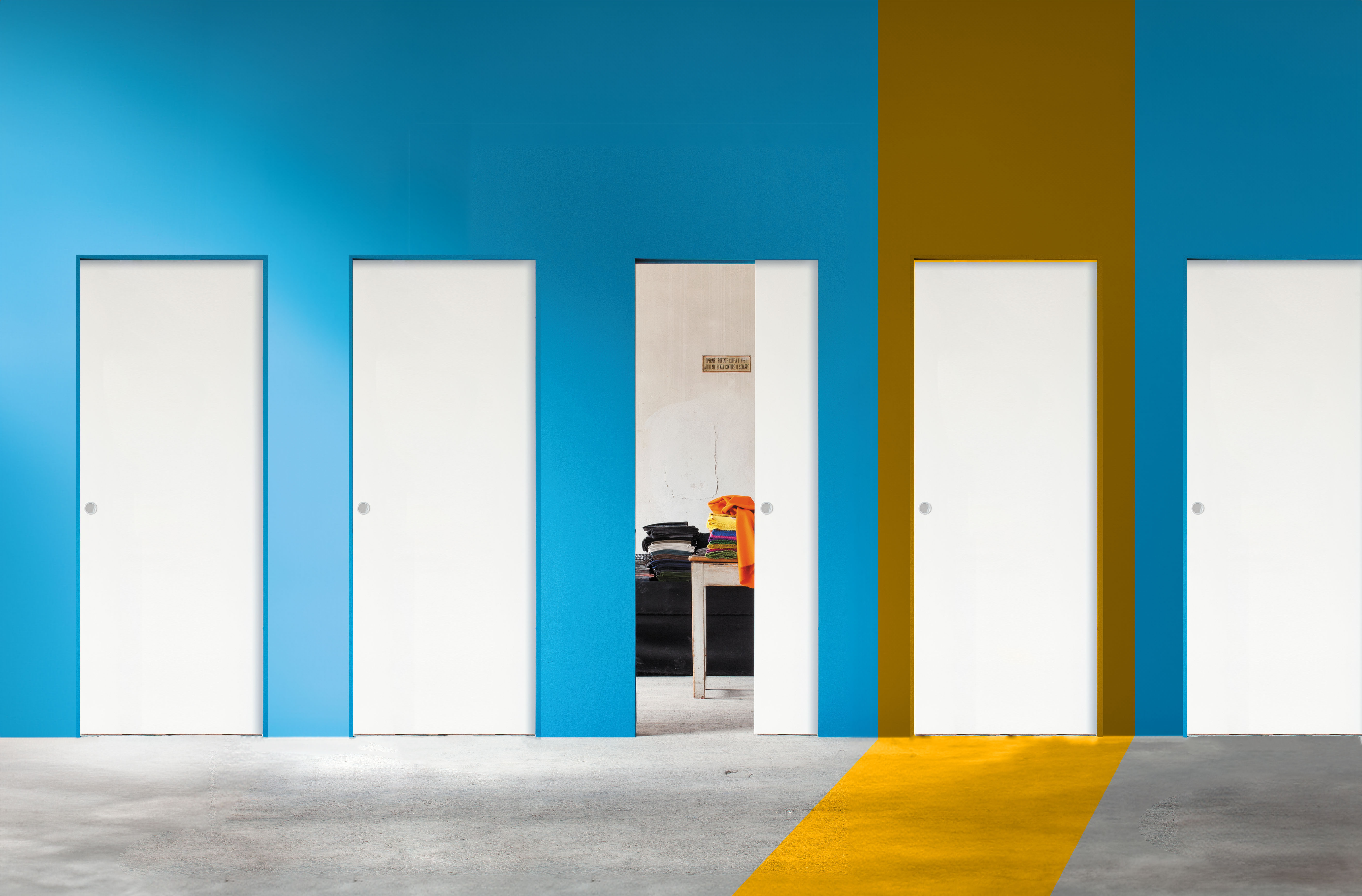 Mur bleu avec 5 portes coulissantes Syntesis® Line dont une mise en valeur par une superposition de couleur orange.