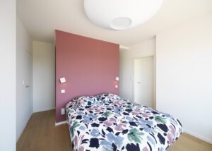 Chambre parentale intégrant Eclisse porte battante affleurante Syntesis® Battant. Architecture d'intérieur et mobilier dans un appartement confié à l'agence ARCHIMEL, à Metz. Photographié en juin 2023.